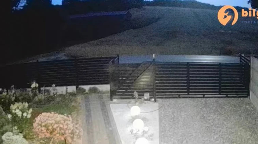 Скриншот із відео камери спостереження в гміні Туробин, де видно нічний пейзаж і потужний спалах від падіння об'єкта
